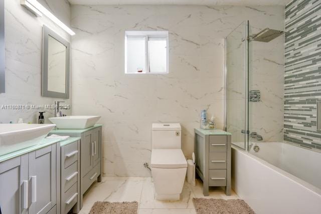 bathroom with double vanity, toilet, marble finish floor, and a sink