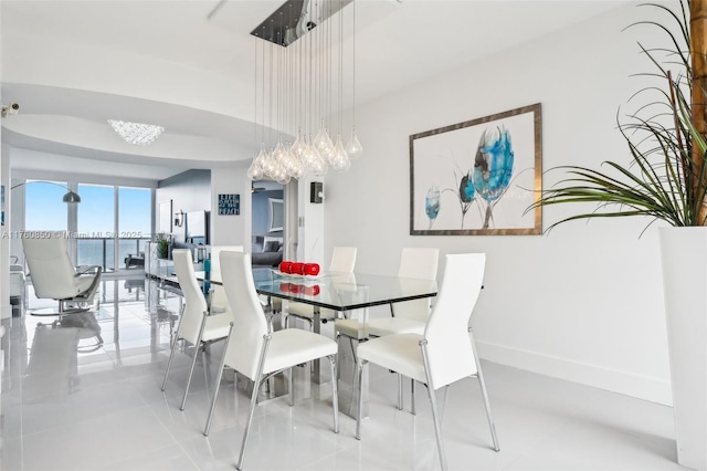 tiled dining room featuring baseboards