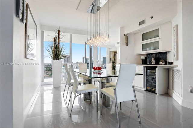 dining area featuring floor to ceiling windows, beverage cooler, visible vents, and a chandelier