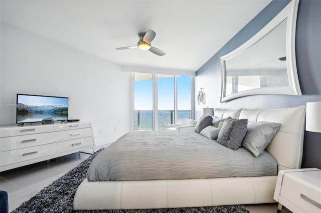 bedroom featuring a ceiling fan and a water view