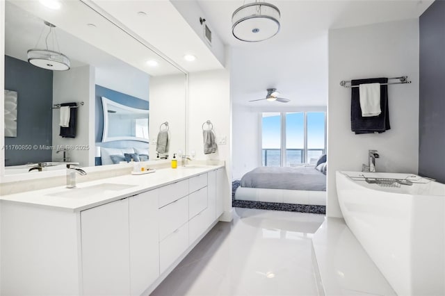 ensuite bathroom featuring double vanity, a soaking tub, ensuite bathroom, and a sink