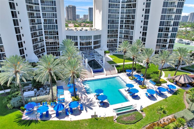 community pool featuring a city view, a community hot tub, and a patio area