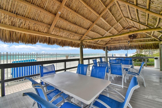 view of patio with outdoor dining space, a gazebo, and a deck with water view