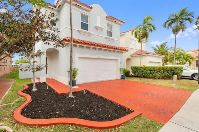 mediterranean / spanish-style house featuring stucco siding, a tiled roof, and an attached garage