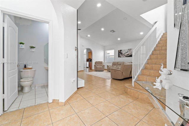 living area with visible vents, stairs, recessed lighting, light tile patterned flooring, and arched walkways