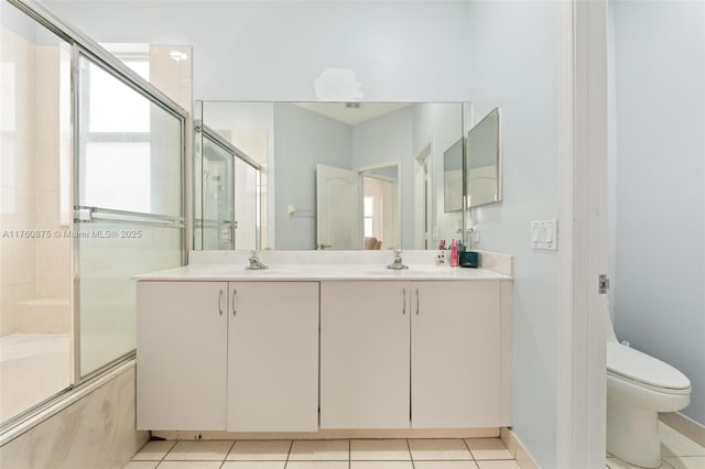 full bathroom featuring double vanity, tile patterned flooring, toilet, and a sink