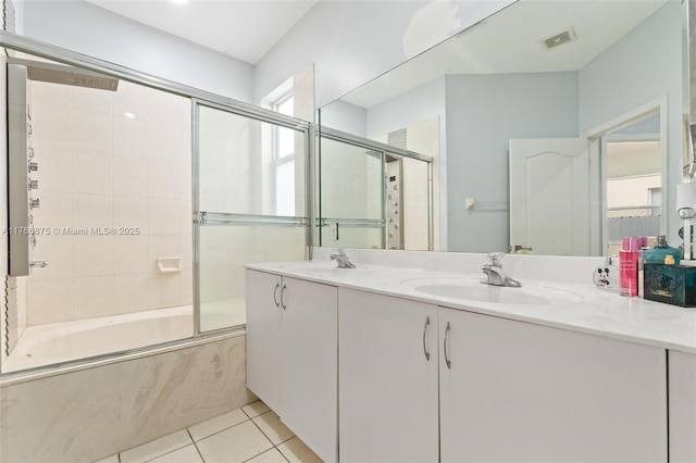 full bath with tile patterned flooring, combined bath / shower with glass door, visible vents, and a sink