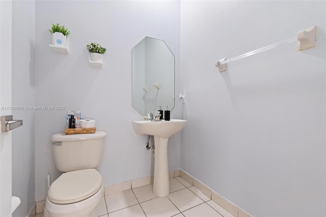 bathroom featuring tile patterned floors, baseboards, and toilet