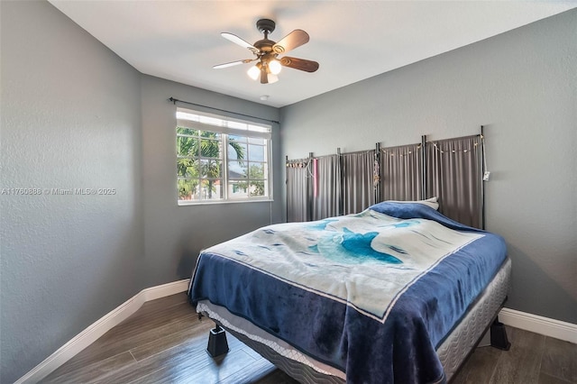 bedroom featuring wood finished floors, baseboards, and a ceiling fan