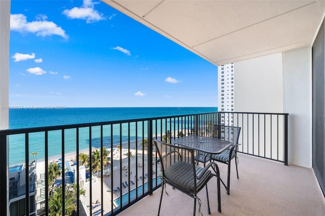 balcony featuring a view of the beach and a water view