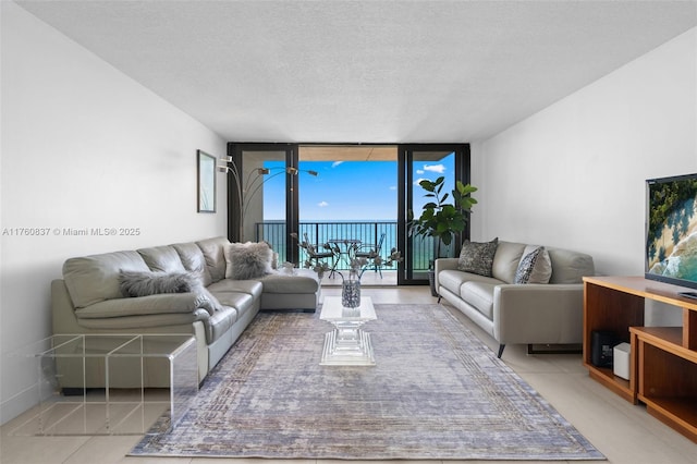 living room featuring tile patterned floors, a textured ceiling, and expansive windows