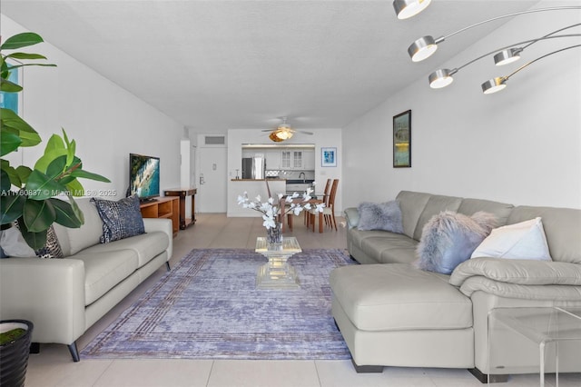 living room with tile patterned floors, a textured ceiling, and a ceiling fan