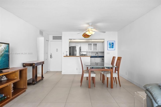 dining area featuring light tile patterned flooring, a ceiling fan, visible vents, and baseboards