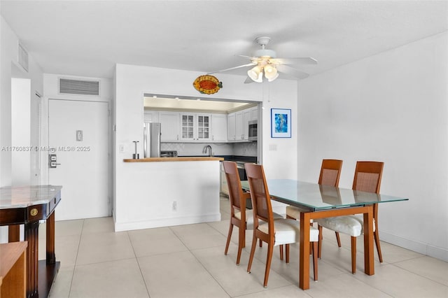 dining room featuring light tile patterned floors, visible vents, and ceiling fan