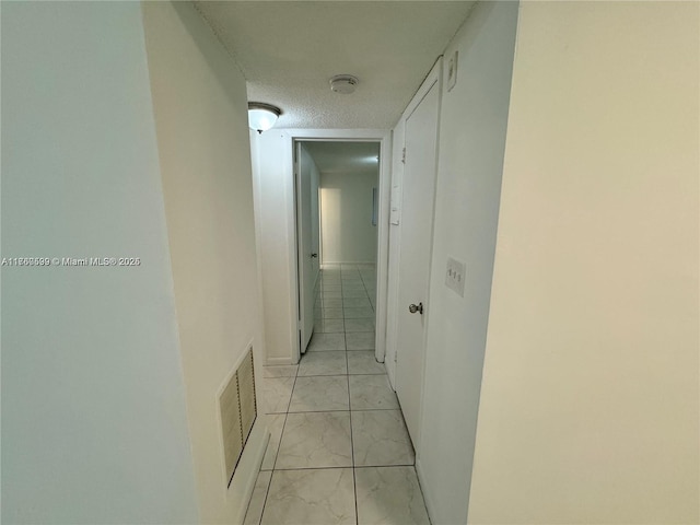 hallway featuring visible vents and a textured ceiling