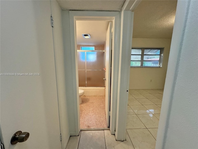 corridor with tile patterned flooring and a textured ceiling