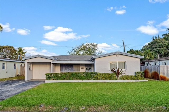 single story home with driveway, a front yard, and fence