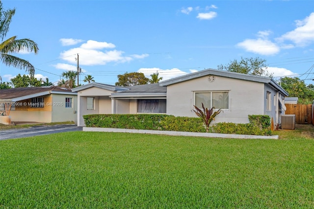 single story home featuring central air condition unit, driveway, a front yard, and fence