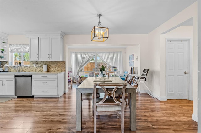 dining room with a notable chandelier, plenty of natural light, and light wood finished floors