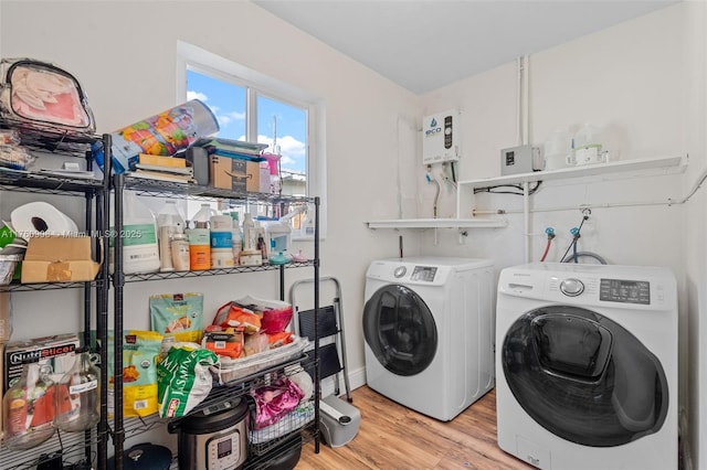 washroom featuring laundry area, washing machine and dryer, and light wood-style flooring