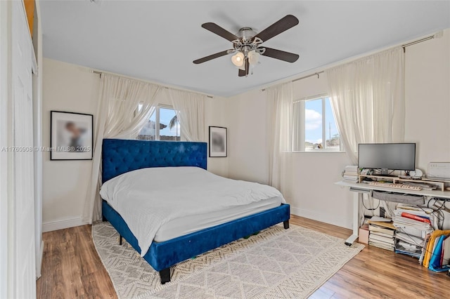 bedroom with wood finished floors, baseboards, and ceiling fan