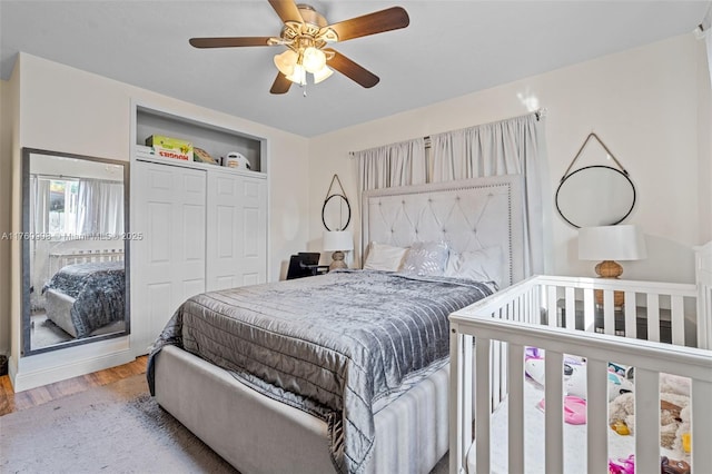 bedroom featuring a ceiling fan, wood finished floors, and a closet