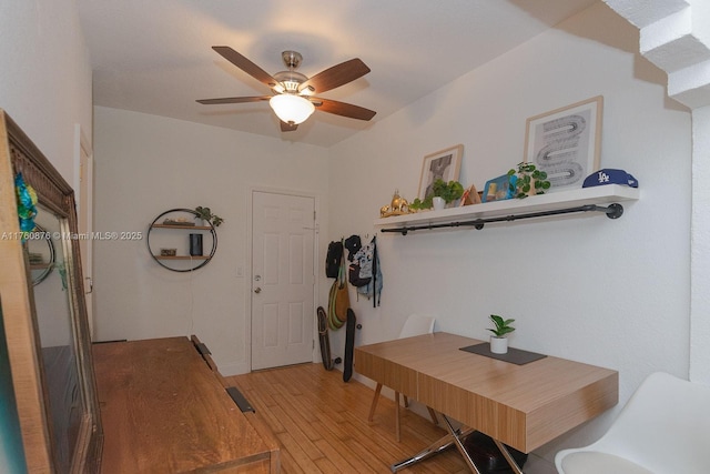 dining room featuring baseboards, a ceiling fan, and light wood finished floors