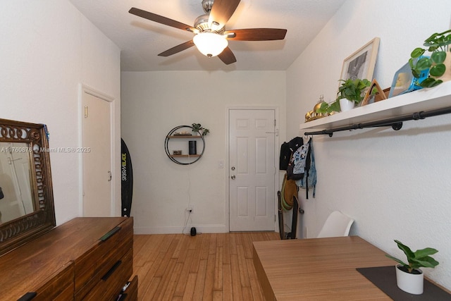 foyer with baseboards, light wood-style floors, and a ceiling fan