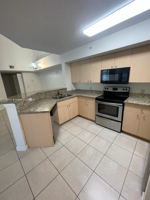 4211 San Marino Blvd Unit 307, West Palm Beach, FL 33409 - kitchen featuring a peninsula, light tile patterned flooring, appliances with stainless steel finishes, and a sink