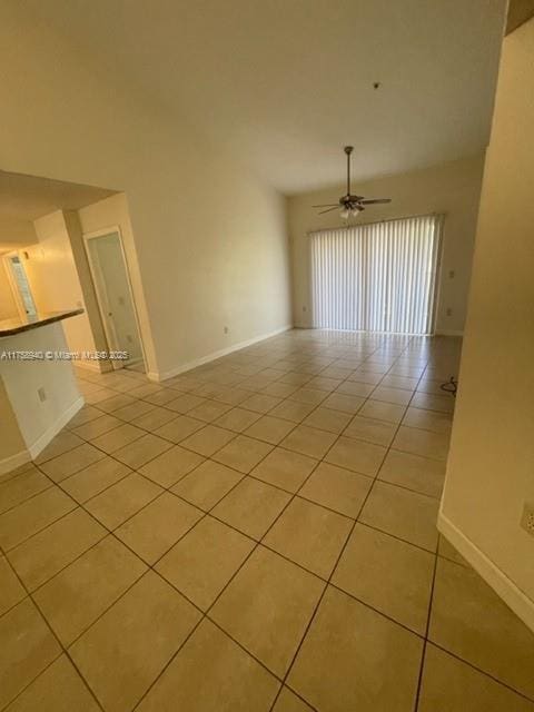 spare room with ceiling fan, baseboards, and light tile patterned flooring