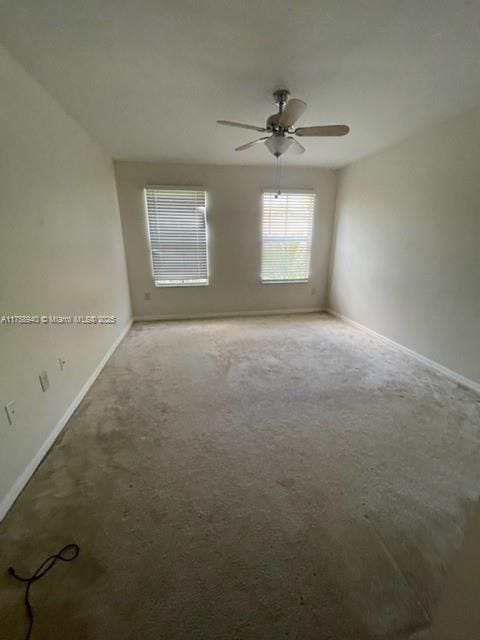 empty room featuring baseboards, carpet floors, and ceiling fan