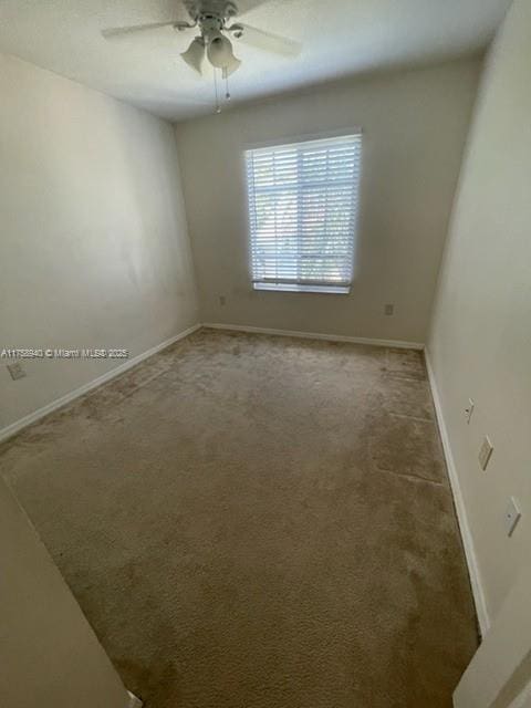 carpeted empty room featuring baseboards and ceiling fan