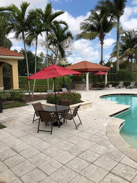 pool with a patio area and fence