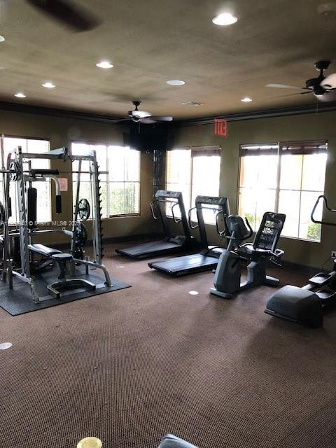 workout area with recessed lighting, ornamental molding, and a ceiling fan