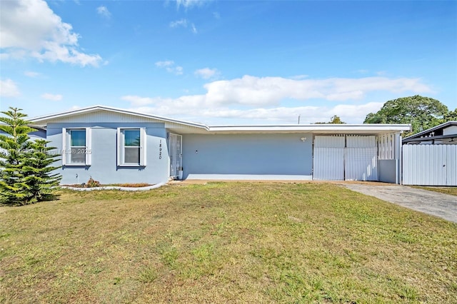 view of front of property featuring driveway, a front lawn, and fence