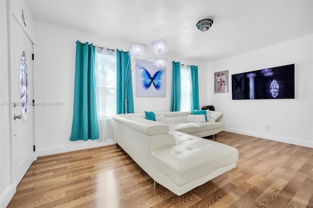 living area featuring light wood-style flooring and baseboards