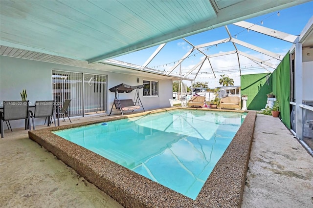 outdoor pool with a patio area and glass enclosure