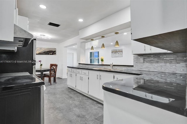 kitchen with range with electric cooktop, a sink, white cabinets, dark countertops, and backsplash