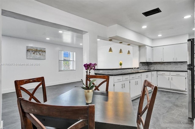 kitchen featuring dark countertops, tasteful backsplash, baseboards, recessed lighting, and white cabinetry