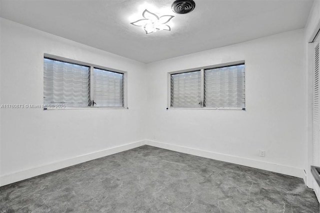 unfurnished room featuring visible vents, baseboards, and concrete flooring