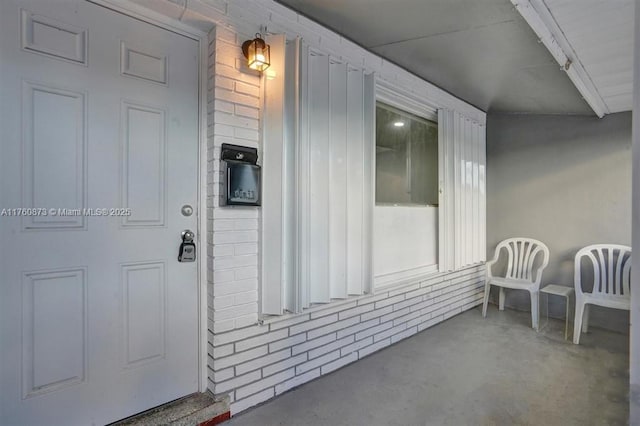 doorway to property with brick siding