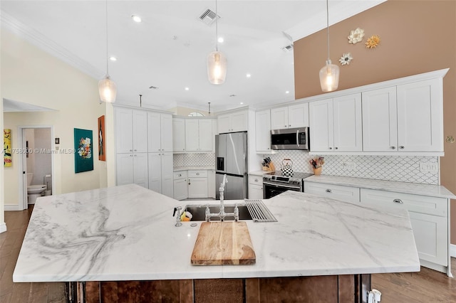 kitchen with visible vents, backsplash, appliances with stainless steel finishes, wood finished floors, and white cabinets