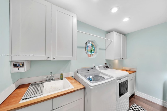 clothes washing area featuring cabinet space, independent washer and dryer, baseboards, and wood finished floors