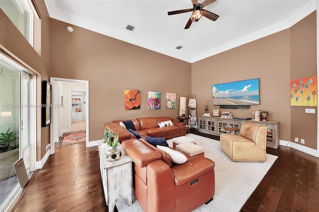 living area featuring dark wood-style floors, crown molding, and baseboards