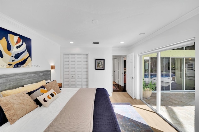 bedroom featuring visible vents, wood finished floors, ornamental molding, and access to outside