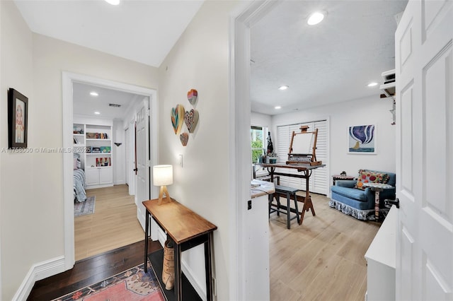 corridor featuring recessed lighting, visible vents, wood-type flooring, and baseboards