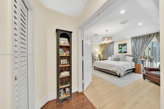 bedroom with visible vents, wood finished floors, recessed lighting, an inviting chandelier, and baseboards