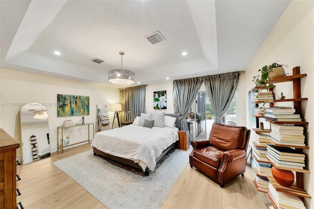 bedroom with visible vents, a tray ceiling, light wood-style flooring, recessed lighting, and access to outside