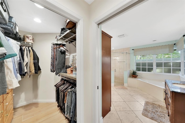 walk in closet with a sink, visible vents, and light tile patterned flooring