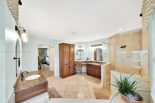 full bath featuring a sink, visible vents, two vanities, and a shower stall